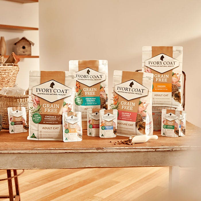 Assorted Ivory Coat cat food packages on a wooden table.